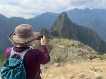 View of ancient Incan ruins of Machu Picchu, Peru, surrounded by misty green mountains
